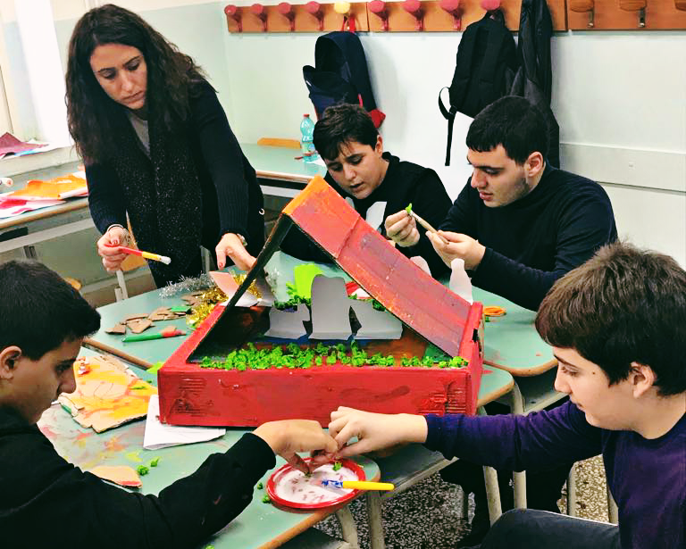 laboratorio abilità sociali: quattro ragazzi con autismo lavorano insieme su un'attività condivisa supervisionati da un terapista